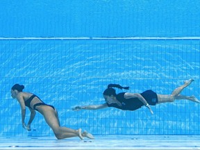 TOPSHOT – Ein Mitglied des Teams USA (R) schwimmt, um die US-Amerikanerin Anita Alvarez (L) während eines Vorfalls im Solo-Finale des freien künstlerischen Schwimmens der Frauen während der Schwimmweltmeisterschaften in Budapest 2022 im Alfred Hajos Swimming vom Boden des Pools zu bergen Komplex in Budapest am 22. Juni 2022. (Foto von Oli SCARFF / AFP) (Foto von OLI SCARFF / AFP via Getty Images)