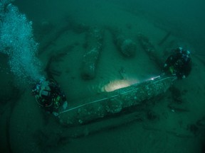 Die Brüder Julian Barnwell und Lincoln Barnwell messen unter Wasser eine Kanone aus dem Schiffswrack der HMS Gloucester, die vor 340 Jahren sank, als sie den König von England, James Stuart, trug, und am 25. Juli 2018 vor der Küste von Norfolk, Großbritannien, entdeckt wurde.
