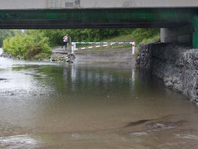 The flooded pathway under the 25th Avenue bridge in Erlton was closed as the Elbow River rose with steady rain in the forecast for Calgary on Monday, June 13, 2022.