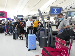 Die Menschen warten am Donnerstag, den 12. Mai 2022, in der Schlange, um am Pearson International Airport in Toronto einzuchecken.