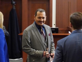 Johnny Depp smiles towards the courtroom gallery in the courtroom as he waits for court be begin after a break at the Fairfax County Circuit Courthouse in Fairfax, Va., Monday, May 16, 2022.