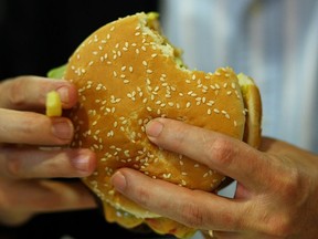 A man eats a Whopper during the opening of the first European Whopper Bar on June 15, 2009 in Munich, Germany. (Photo by Miguel Villagran/Getty Images)