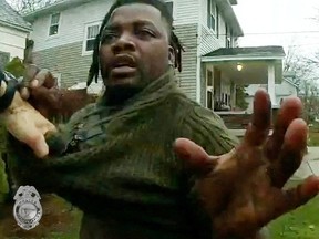A Grand Rapids Police officer grasps the shirt of Patrick Lyoya during a traffic stop, shortly before Lyoya was shot dead by the officer during a scuffle on a suburban front lawn in Grand Rapids, Michigan, April 4, 2022 in a still image from police body camera video.