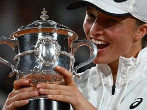 Poland's Iga Swiatek poses with the trophy after winning against Coco Gauff of the U.S. at the end of their women's single final match on day fourteen of the Roland-Garros Open tennis tournament at the Court Philippe-Chatrier in Paris on June 4, 2022.