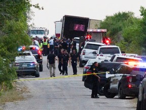 Law enforcement officers work at the scene where people were found dead inside a trailer truck in San Antonio, Texas, June 27, 2022.