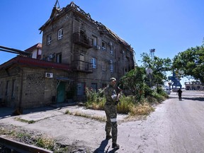 A Russian serviceman patrols a territory of the sea port in the city of Mariupol on June 12, 2022, amid the ongoing Russian military action in Ukraine.