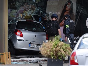 Police investigators stand near a car that plowed into pedestrians and then smashed into a Douglas perfume store on Tauentzienstrasse on June 8, 2022 in Berlin, Germany.