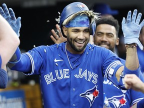 Toronto Blue Jays left fielder Lourdes Gurriel Jr. (13) receives congratulations from teammates after he hit a home run against the Detroit Tigers at Comerica Park.