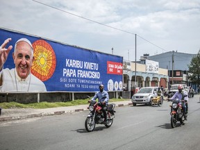 People drive past a banner welcoming Pope Francis to Goma, Democratic Republic of Congo, Friday June 10, 2022. Plans continue to move forward for Pope Francis' visit to Canada even as the pontiff cancels a planned trip to Africa on doctors' orders.