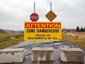 A warning sign and street blockade are seen near the scene of a landslide in the town of St. Jude on October 25, 2010.