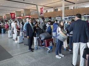 Passengers lineup at the check in counter at Pierre Elliott Trudeau airport in Montreal, Wednesday, June 29, 2022.
