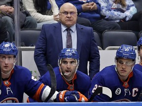 FILE - New York Islanders head coach Barry Trotz, top, looks on in the third period of an NHL hockey game against the Minnesota Wild, Jan. 30, 2022, in Elmont, N.Y. A Winnipeg brewery says it will give Trotz free beer for life if he returns to his native province to coach the Jets.