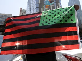 A man holds an African-American flag during a demonstration in Chicago on June 19, 2020.