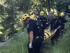 Firefighters' rope and rescue team carry a women who fell down an embankment behind Pariliament Hill. She suffered minor injuries.