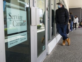 People line up outside the Service Canada office on W. Broadway in Vancouver, Friday, April 22, 2022.