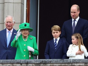 Prince Charles, Prince of Wales, Queen Elizabeth II, Prince George of Cambridge, Prince William, Duke of Cambridge and Princess Charlotte of Cambridge stand on a balcony during the Platinum Jubilee Pageant on June 5, 2022 in London.