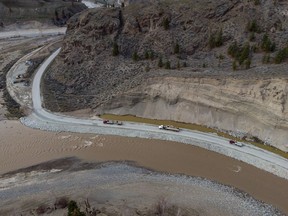 Trucks haul loads of rock on a section of Highway 8 along the Nicola River, which had to be rebuilt after it was washed away during November flooding affecting the Shackan Indian Band, northwest of Merritt, B.C., on Thursday, March 24, 2022.