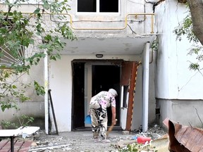 In diesem Standbild aus einem undatierten Handout-Video, das am 17. Juni 2022 veröffentlicht wurde, fegt eine Frau nach tödlichen Raketenangriffen auf ein Wohngebiet von Mykolajiw inmitten des russischen Angriffs auf die Ukraine aus einem Wohnhaus.