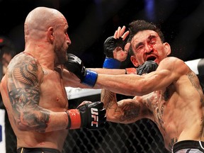 Alexander Volkanovski (left) punches Max Holloway in their featherweight title bout during UFC 276 at T-Mobile Arena on July 2, 2022 in Las Vegas.