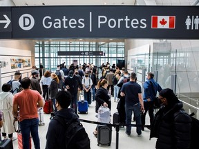 Travellers crowd the security queue in the departures lounge at the start of the Victoria Day holiday long weekend at Toronto Pearson International Airport in Mississauga on May 20, 2022.
