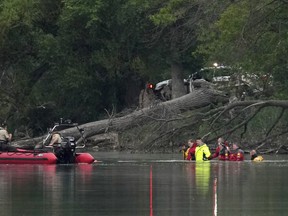Teams in dry suits and Ramsey County Sheriff's deputies search for the bodies of a mother and her three children at Vadnais Lake, Saturday, July 2, 2022, in Vadnais Heights, Minn.