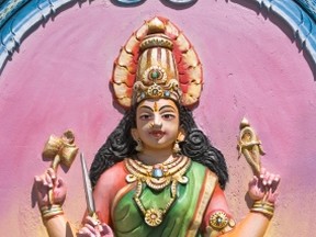 Some believe an infant born with four arms and four legs to be a reincarnation of the many-armed Hindu goddess Lakshmi, seen here in a painted carving located in a Tamil temple of Mauritius.