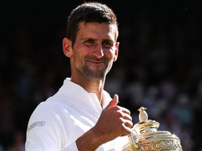 Serbia's Novak Djokovic smiles as he holds his trophy after defeating Australia's Nick Kyrgios during the men's singles final tennis match on the 14th day of the 2022 Wimbledon Championships at The All England Tennis Club in Wimbledon, southwest London, on July 10, 2022.