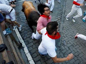 Ein Läufer wird während des Stierlaufs beim San Fermin Festival in Pamplona, ​​Spanien, am 11. Juli 2022 von einem Stier getroffen.