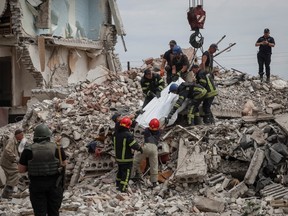 Retter bergen am 10. Juli 2022 in der Stadt Chasiv Jar in der Region Donezk, Ukraine, eine Leiche aus einem Wohngebäude, das durch einen russischen Militärschlag inmitten der russischen Invasion in der Ukraine beschädigt wurde.