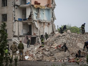 Rescuers work at a residential building damaged by a Russian military strike in the town of Chasiv Yar, in Donetsk region, Ukraine, July 11, 2022.