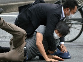 Ein Mann, von dem angenommen wird, dass er den ehemaligen japanischen Premierminister Shinzo Abe erschossen hat, wird am 8. Juli 2022 von Polizisten auf der Yamato Saidaiji Station in Nara festgehalten.