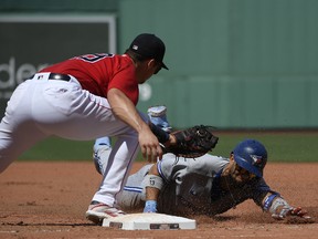 Toronto Blue Jays designated hitter Lourdes Gurriel Jr. (13) slides safely back to first ahead of the tag by Boston Red Sox first baseman Bobby Dalbec (29) after hitting a single during the fourth inning at Fenway Park.