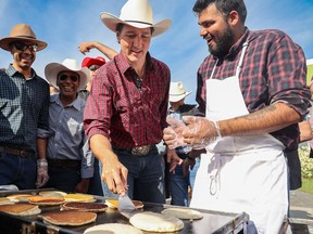 Prime Minister Justin Trudeau flips pancakes at MP George Chahal's Calgary Stampede Breakfast at the Genesis Centre in Calgary on Sunday, July 10, 2022.