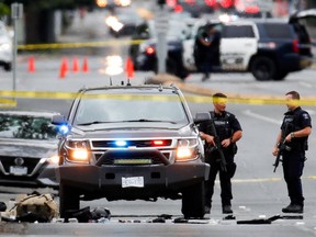 Polizisten versammeln sich, nachdem zwei bewaffnete Männer, die eine Bank betraten, bei einer Schießerei mit der Polizei in Saanich, British Columbia, Kanada, am 28. Juni 2022 getötet wurden.