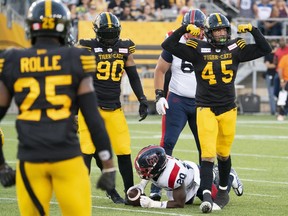 Hamilton Tiger Cats linebacker Jovan Santos-Knox (45) celebrates his tackle on Montreal Alouettes running back Jeshrun Antwi (20) during first half CFL football game action in Hamilton July 28, 2022.