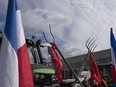 FILE- Some 25 tractors were used to blockade a distribution center for supermarket chain Albert Heijn in the town of Zaandam, just north of Amsterdam, Monday, July 4, 2022. Dutch farmers angry at government plans to slash emissions used tractors and trucks Monday to blockade supermarket distribution centers, the latest actions in a summer of discontent in the country's lucrative agricultural sector.