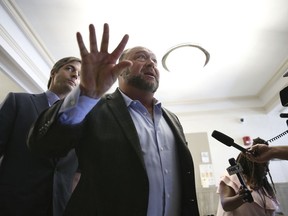 Alex Jones talks to media during a midday break during the trail at the Travis County Courthouse in Austin, Texas, Tuesday, July 26, 2022.