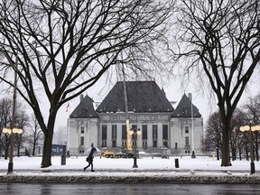 A pedestrian walks past the Supreme Court of Canada in Ottawa on Thursday, Nov. 26, 2020. Canada's highest court has unanimously upheld the first-degree murder conviction of a man found guilty of a January 2015 slaying near Prince George, B.C.