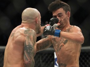 Alexander Volkanovski (red gloves) and Max Holloway (blue gloves) fight during UFC 276 at T-Mobile Arena.