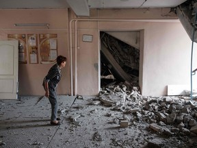Ein Lehrer untersucht die Zerstörung einer Schule, die am 24. Juli 2022 durch einen Beschuss in Bachmut in der Region Donezk zerstört wurde.