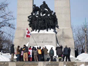 Menschen umzingeln das Grab des unbekannten Soldaten am National War Memorial während einer Kundgebung gegen die COVID-19-Beschränkungen in Ottawa am 30. Januar 2022.