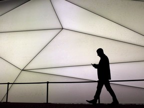 A man looks at his phone during the Mobile World Congress wireless show in Barcelona, Spain, on February 27, 2017. Xplore Mobile Inc. which supplies service to Manitoba will be shutting down at the end of August.