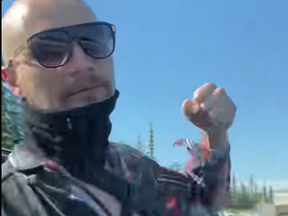 A still from a video that's been widely shared on social media showing a man winding up to punch a car window in a Calgary Superstore parking lot on Friday, Aug. 12, 2022.