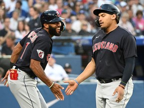 Cleveland Indians first baseman Josh Naylor (22) is greeted by shortstop Amed Rosario (1) after hitting a home run against the Toronto Blue Jays at Rogers Centre.