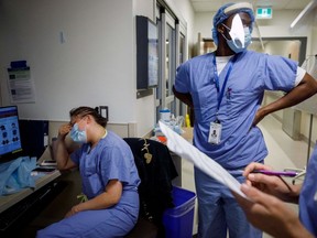 A nurse holds her head as nurses care for patients suffering from coronavirus disease (COVID-19) at Humber River Hospital's Intensive Care Unit, in Toronto, Ontario, Canada, on April 28, 2021.