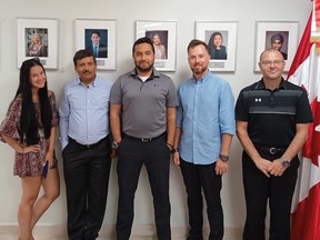 The Pivot Airlines flight crew take a photo in front of portraits of Canada’s leaders on the wall of the Canadian Embassy in the Dominican Republic.