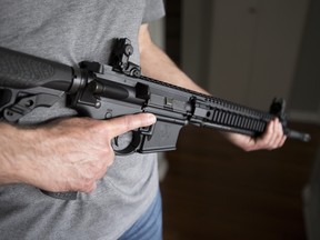 A restricted gun licence holder holds a AR-15 at his home in Langley, B.C. on May 1, 2020. A leading proponent of stricter gun control says allowing owners of recently banned firearms to keep them would make it easier for a different government to reverse the ban in future. In a letter to Public Safety Minister Bill Blair, the group PolySeSouvient urges the Liberal government to implement a mandatory buyback program for all assault-style guns. THE CANADIAN PRESS/Jonathan Hayward ORG XMIT: JCO502