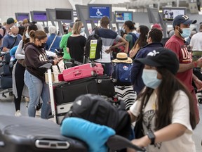 Travellers line up at Toronto Pearson International Airport’s Terminal 1 as delays continue, Thursday July 7, 2022.