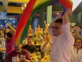 A man waves a rainbow flag after Singapore's Prime Minister Lee Hsien Loong announces that Singapore will decriminalize gay sex, in Singapore, Sunday, Aug. 21, 2022, in this screen grab obtained from a social media video.