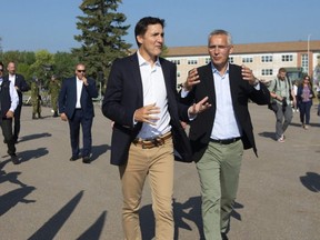 Prime Minister Justin Trudeau, left, and NATO Secretary General Jens Stoltenberg speak together after leaving a press conference at 4 Wing Cold Lake air base in Cold Lake Alta., Friday, Aug. 26, 2022.